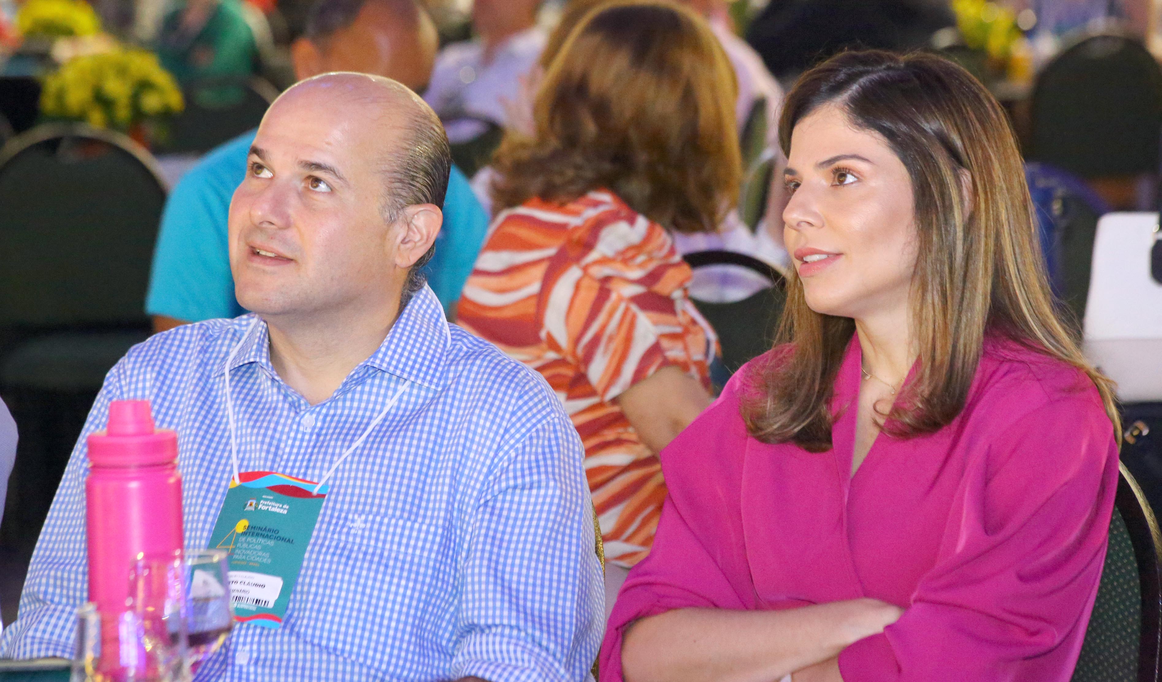 prefeito e primeira-dama sentados lado a lado assistindo apresentação